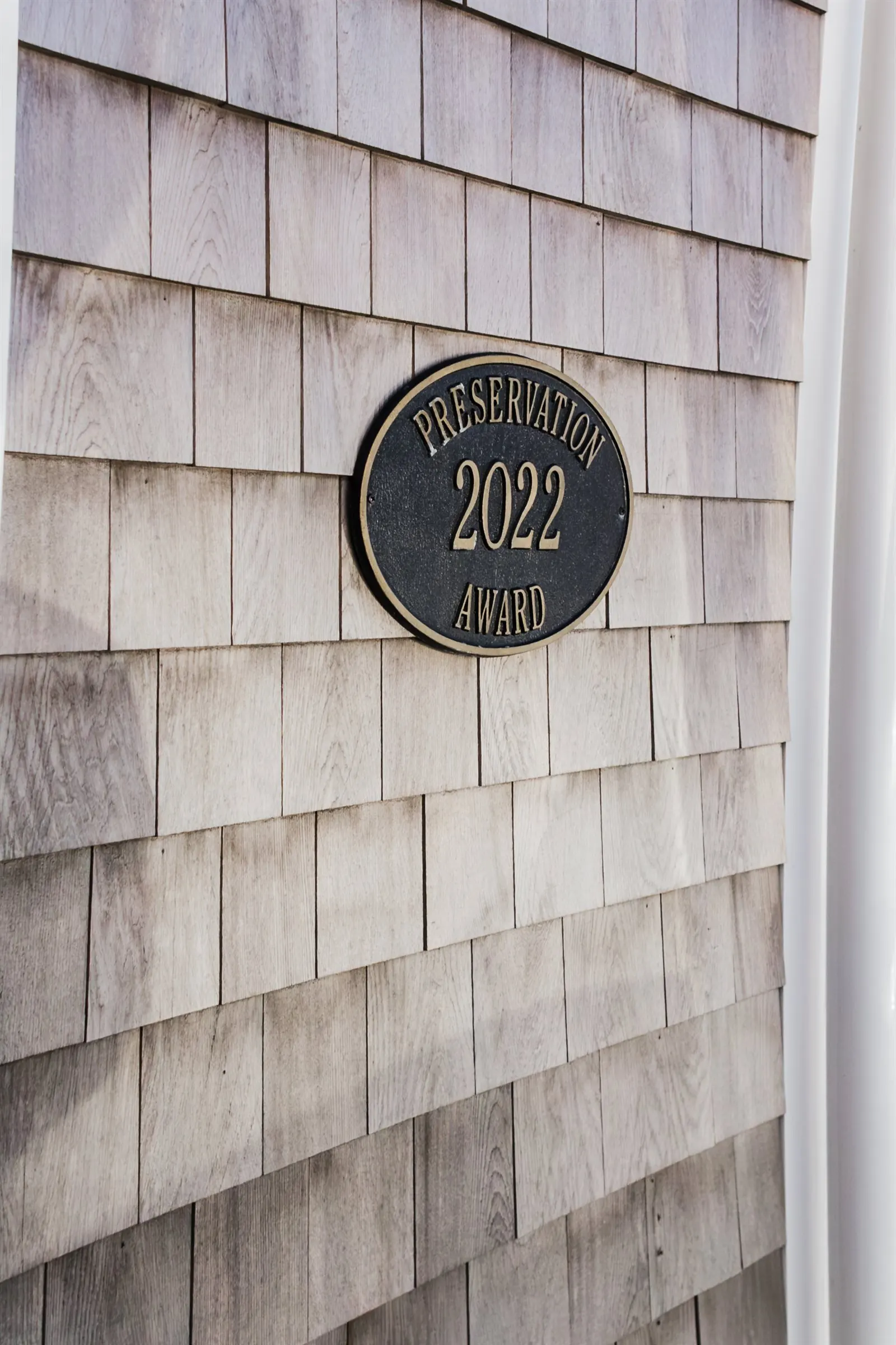 2022 Chatham Preservation Award plaque mounted on cedar shingle siding